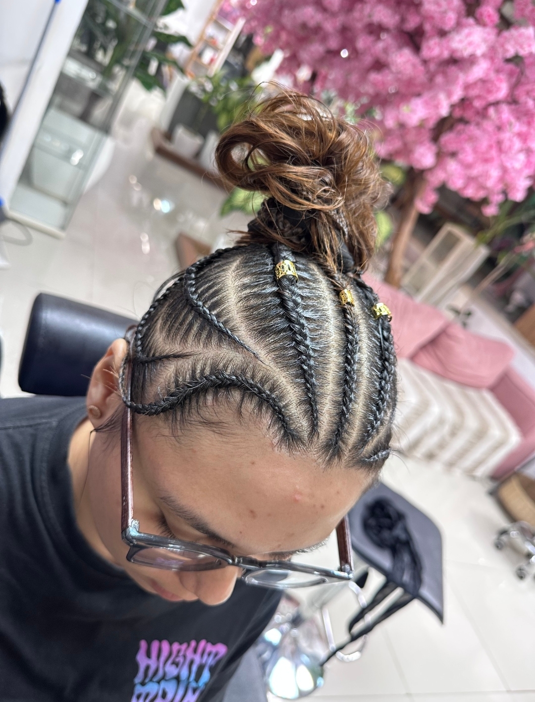 Custom cornrows with gold rings on female client — premium braiding service